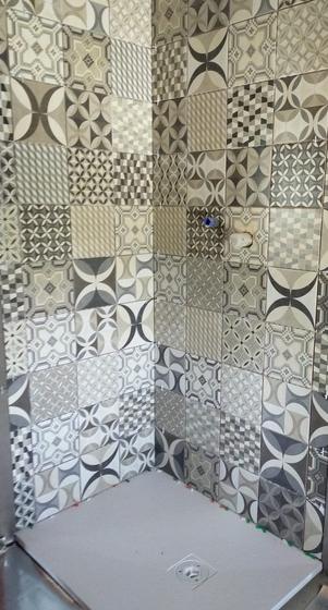 Doccia con pareti rivestite in piastrelle decorate a fantasie geometriche bianche, grigie e beige, piatto doccia grigio