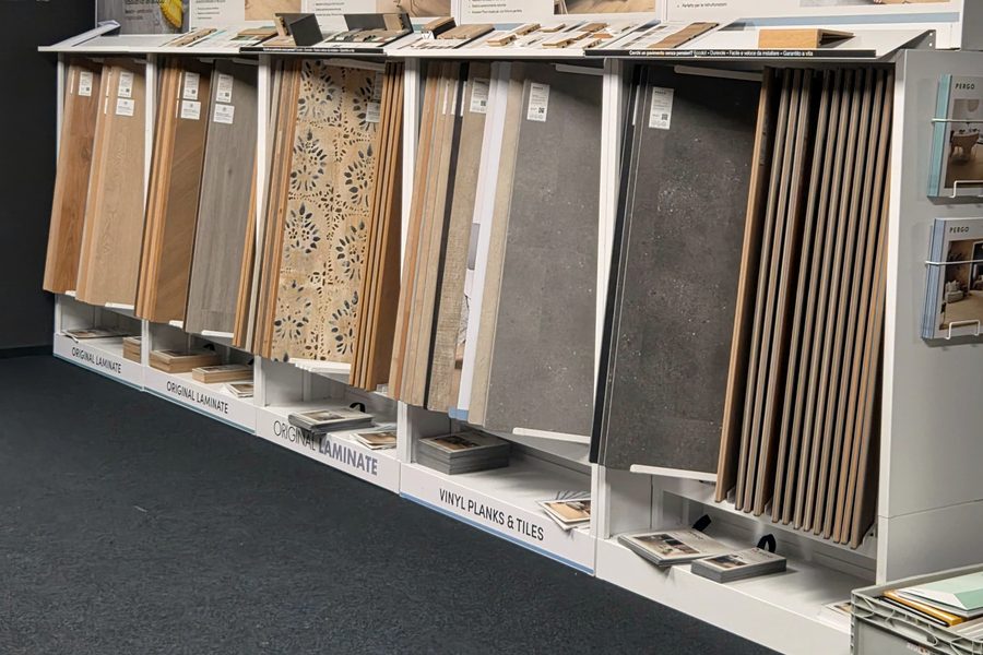 Espositore dello showroom con campioni di pavimenti a doghe, laminato e vinilico, allineati sul banco